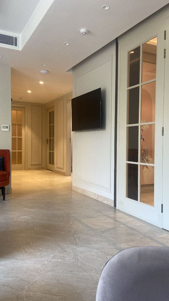Corridor with panelled doors and polished stone floor