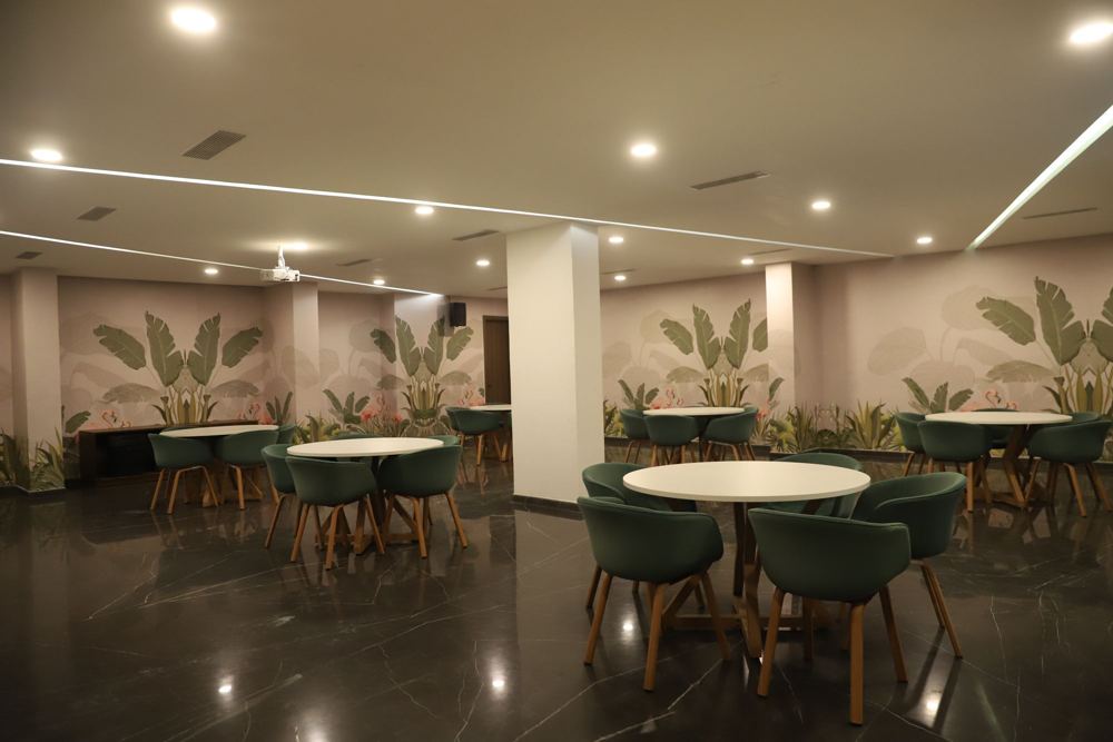 Cafe with a tropical leaf mural and green shell chairs