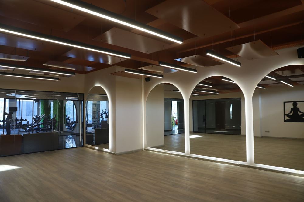 Yoga studio with arched mirrors and suspended copper ceiling panels